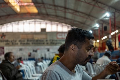 Jocelino da Silva recibe una ración de comida de una organización social.