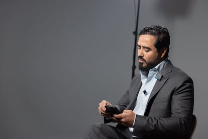El eurodiputado elector, Alvise Pérez, consulta su móvil en un momento de la entrevista con EL PAÍS.