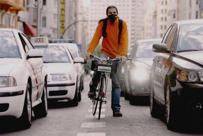 Un ciclista con máscara circula por la Gran Vía de Madrid.