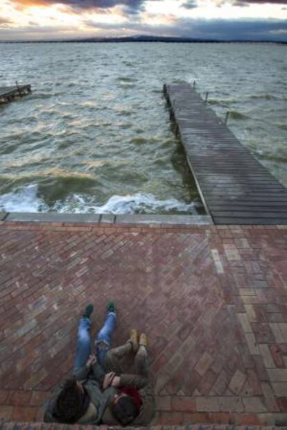 Una pareja observa el atardecer desde el embarcadero de la Gola de Pujol del Parque Natural de L'Albufera (Valencia), uno de los enclaves perfectos para gritar a los cuatro vientos que se está enamorado.