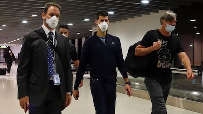 Novak Djokovic (en el centro), camina en el aeropuerto de Melbourne antes de tomar el avión de vuelta a Europa.