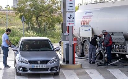 Un operario hace mediciones y llena los depósitos de carburante desde un camión cisterna en una gasolinera de Sevilla.