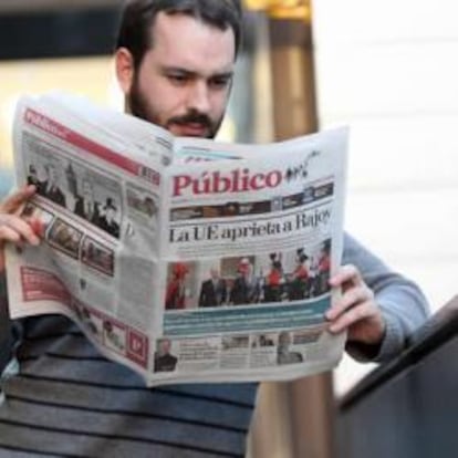 Un lector con un ejemplar del periódico Público