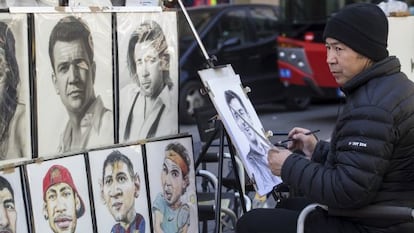 Un dibujante de la Rambla realiza un retrato 