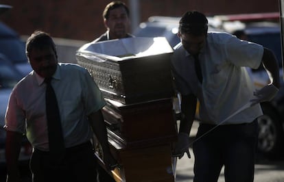 Trabajadores de la funeraria trasladan fretros al polideportivo municipal de la ciudad de Santa Mara, Brasil. Al menos 233 jvenes murieron asfixiados y aplastados en un incendio declarado en la discoteca Kiss de esta localidad.