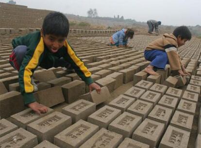Niños en edad escolar trabajando en una fábrica de ladrillos en Lima.