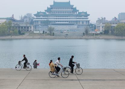 Varias personas pasean en bicicleta a orillas del río Taedong, en Pyongyang, Corea del Norte.