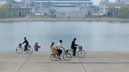 Varias personas pasean en bicicleta a orillas del río Taedong, en Pyongyang, Corea del Norte.