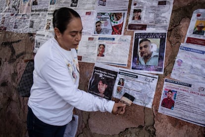 Una integrante de un colectivo de búsqueda pega fichas de personas desaparecidas en Zacatecas, en septiembre de 2024.