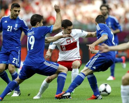 Lewandoiwski intenta no perder el balón, rodeado de adversarios