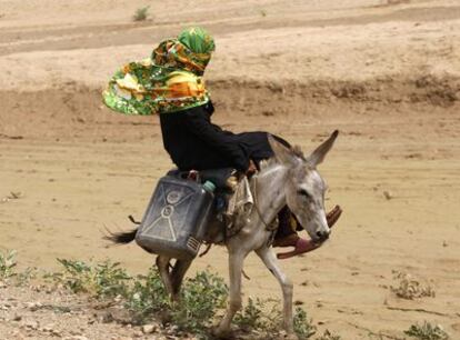 Una campesina busca agua a lomos de un burro en una zona desértica de Yemen, país azotado por la sequía.
