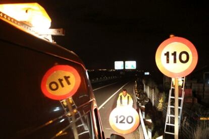 A worker changes the road sign on the A-55 motorway in Madrid.