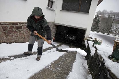 Un señor se ayuda con una pala para quitar la nieve de la puerta de su vivienda, en Pamplona (Navarra) el 13 de enero.