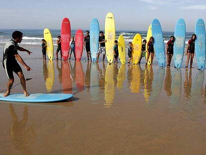 Clase de surf en la playa de la Barrosa, un arenal que se extiende a lo largo de ocho kilómetros en la costa gaditana, cerca de Chiclana de la Frontera.