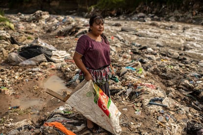 Gregoria García recolecta basura en el río, el 6 de agosto.