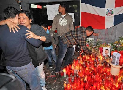 La madre de Luis Polanco Peralta, Ana Mercedes, se abraza a un allegado mientras Faustino, el padre, se inclina sobre el altar instalado en el barrio de Tetuán en el lugar donde fue asesinado.