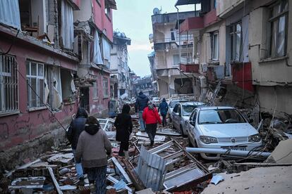 Varios vecinos de la región turca de Hatay (sur del país) caminan entre los escombros. Muchos de ellos esperan noticias de sus seres queridos, atrapados bajo los edificios en ruinas.   