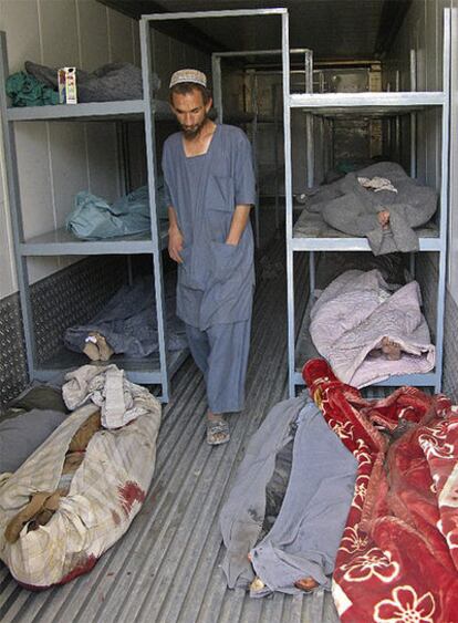 Un hombre camina entre los cuerpos sin vida de los civiles que viajaban en el autobús en Kandahar.