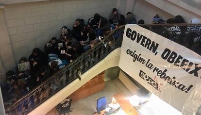 Los estudiantes, sentados en la escalera del vestíbulo del departamento.