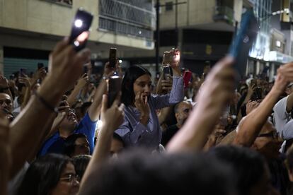 Personas reaccionan en las afueras del centro de votación Andrés Bello en Caracas.