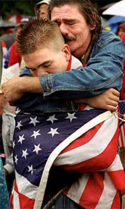 Un padre y un hijo se abrazan en Washington durante un homenaje a las víctimas.