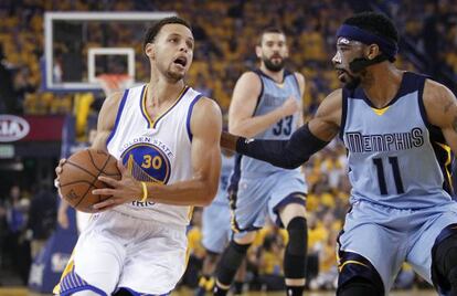 Curry, con el balón, ante Conley.