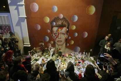 Homenajes por la muerte de David Bowie frente a un mural del cantante dibujado por el artista Jimmy C, en Brixtol, Londres.
