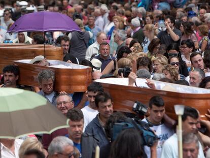 Un grupo de personas porta a hombros seis ataúdes con personas vivas dentro, con motivo de la procesión de Santa Marta, en As Neves (Pontevedra), el 29 de julio de 2019.