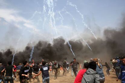 Manifestantes palestinos huyen del gas lacrimógeno disparado por las fuerzas de seguridad israelíes cerca de la ciudad de Khan Yunis, en la franja de Gaza.