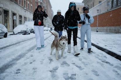 Viandantes caminando por las calles nevadas de Roma (Italia), el 26 de febrero de 2018.