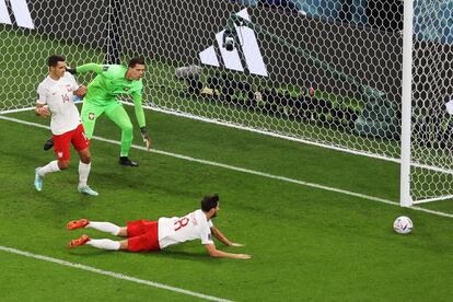 Wojciech Szczensy (segundo por la izquierda), y los jugadores Jakub Kiwior (a la izquierda) y Bartosz Bereszynski miran la pelota tras una jugada.