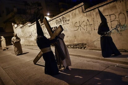 El 'Ensacado' (c) carga una cruz durante la procesión de la Hermandad del Silencio del Santísimo Cristo del Rebate, en Tarazona (Zaragoza).