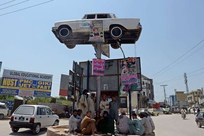 Trabajadores paquistaníes se sientan bajo la sombra  en una rotonda en Rawalpindi.