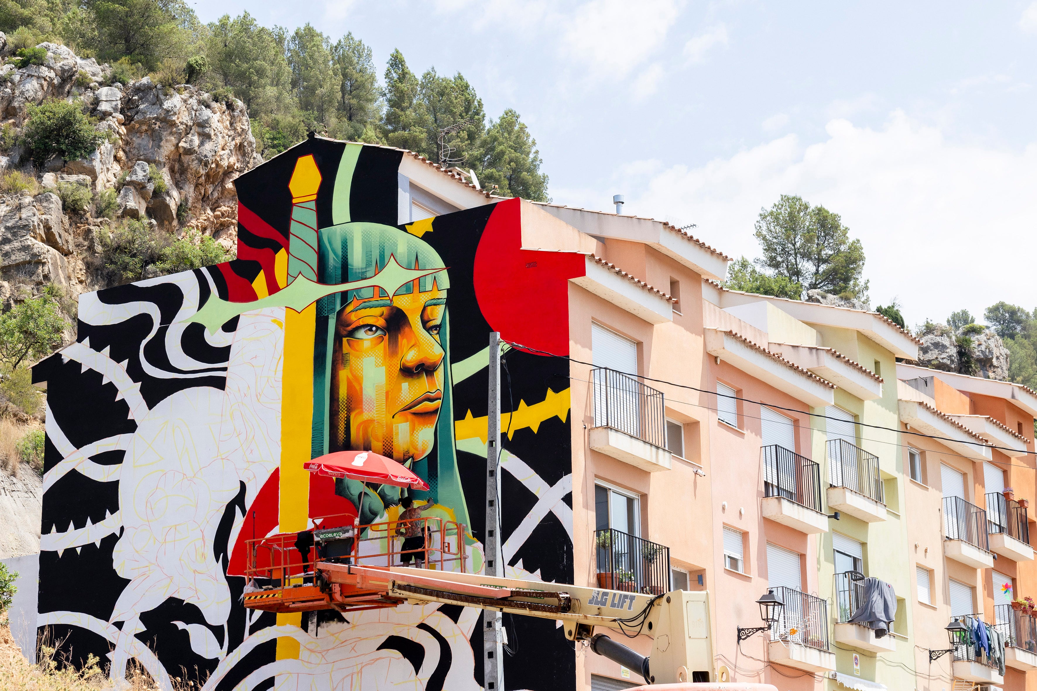 El muralista Santa Gross pinta una fachada en Fanzara, en Castellón, durante el festival de arte urbano MIAU.