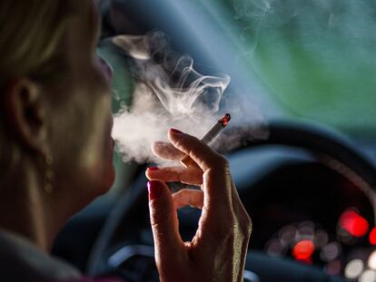 11 May 2022, Schleswig-Holstein, Flensburg: A woman sits behind the steering wheel of her car with a lit cigarette. Photo: Axel Heimken/dpa (Photo by Axel Heimken/picture alliance / Getty Images)