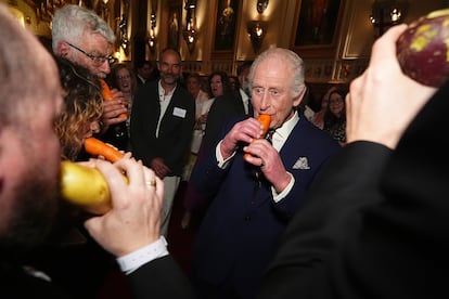 Carlos III tocando una zanahoria tallada en forma de flauta, en una ceremonia en el castillo de Windsor con la London Vegetable Orchestra, el 3 de abril de 2025.