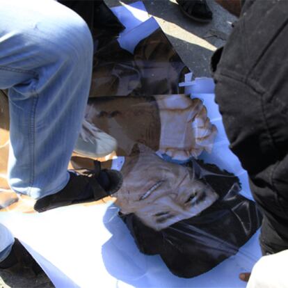 Varios manifestantes pisotean un cartel con la imagen de Gadafi, ayer en Zauiya.