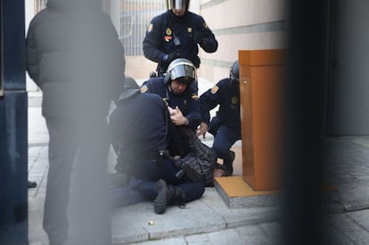 Policías reducen a un manifestante a las puertas de la Asamblea de Madrid.
