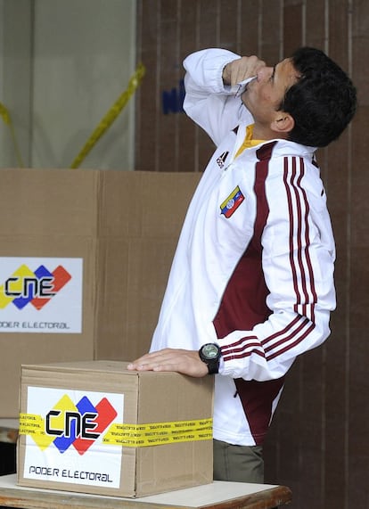 El candidato presidencial opositor Henrique Capriles besa su voto antes de introducirlo en la Urna en Caracas.