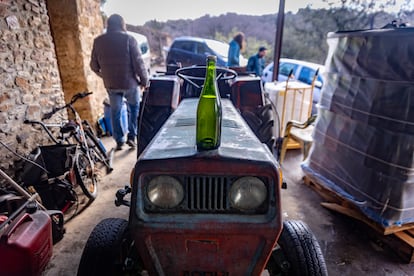 Una botella de vino blanco espumoso de la añada 2017 sobre un tractor en la bodega de Carles Alonso.