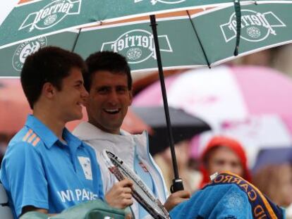 Djokovic, con el recogepelotas al que quit&oacute; el paraguas para resguardarle de la lluvia.