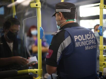 Un agente de la Policía Municipal de Madrid realiza un control de movilidad en una línea de autobús que pasar por el distrito de Puente de Vallecas, el lunes.