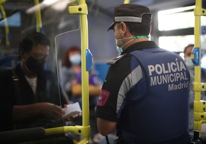 Un agente de la Policía Municipal de Madrid realiza un control de movilidad en una línea de autobús que pasar por el distrito de Puente de Vallecas, el lunes.