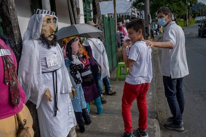 Niños y adultos pasan curiosos por el frente de la venta de muñecos que Silvia tiene hace más de 35 años, en Rionegro, Antioquia, el 29 de diciembre de 2022