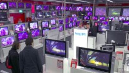 Clientes en una tienda Media Markt miran televisores.