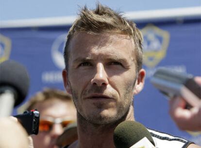 El futbolista británico, ex fichaje estrella del Real Madrid, arrastra su estela mediática adonde quiera que vaya. En la foto, David Beckham atiende a los periodistas que montan guardia a la salida de un entrenamiento en el club Los Ángeles Galaxy's, en California. (Texto: ELPAÍS.com)