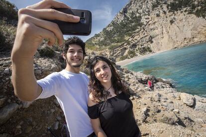 Una pareja se retrata con el móvil en la playa del Coll Baix, en Alcúdia (Mallorca).