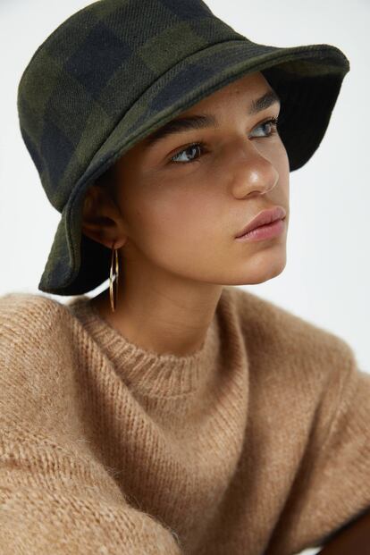 Si te encanta el estilo british, hazte con este gorro tipo pescador de cuadros verdes y negros. Te protegerá de la humedad y el frío. Lo tienes en Pull & Bear con descuento por 5,99 euros.