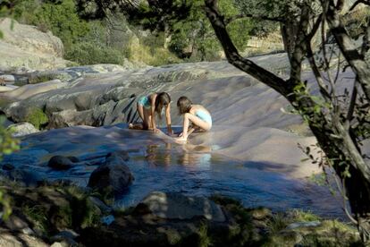 Dos niñas juegan y se bañan en Charca Verde de la Pedriza Manzanares el Real.