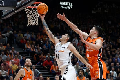 El alero argentino del Real Madrid Gabriel Deck (2d) entra a canasta ante el ala pvot del Valencia Basket Jaime Pradilla en el partido de Liga Endesa de baloncesto que se disputa este domingo en la Fonteta.